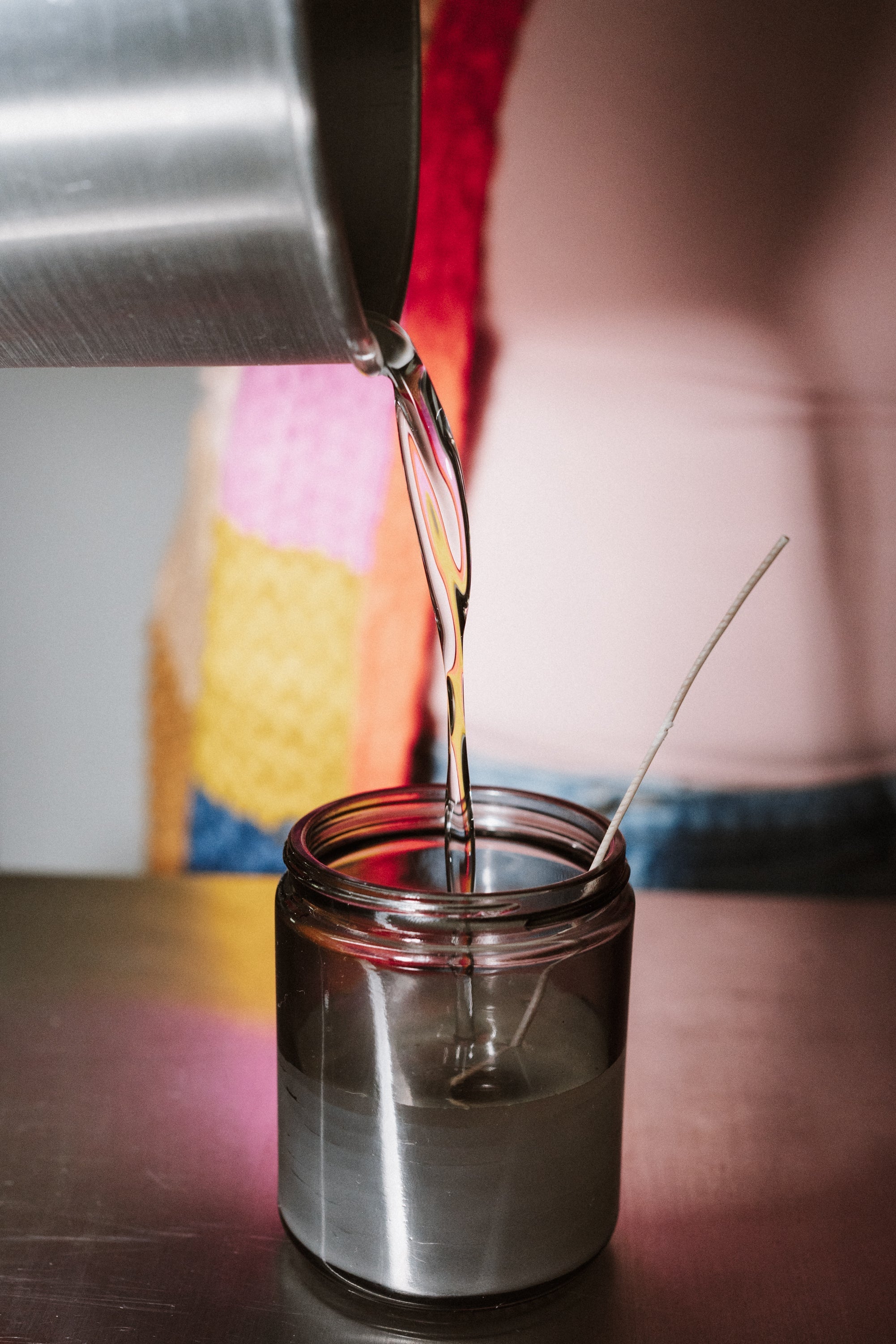 Coconut apricot wax being poured into a candle jar during hand-poured candle making at 1983.